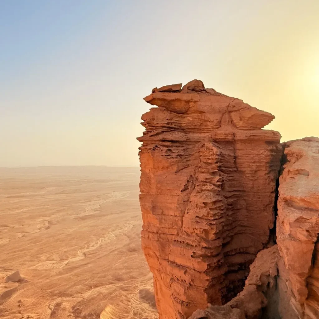 A group enjoying the best desert safari package Riyadh with thrilling dune bashing and camel rides in the golden desert dunes at sunset.