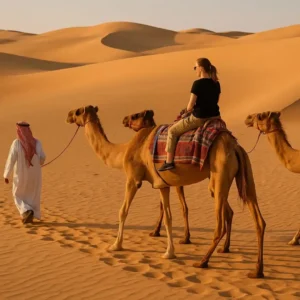 Tourists enjoying a Must-Do Adventure in Saudi Arabia with dune bashing, camel rides, and desert exploration
