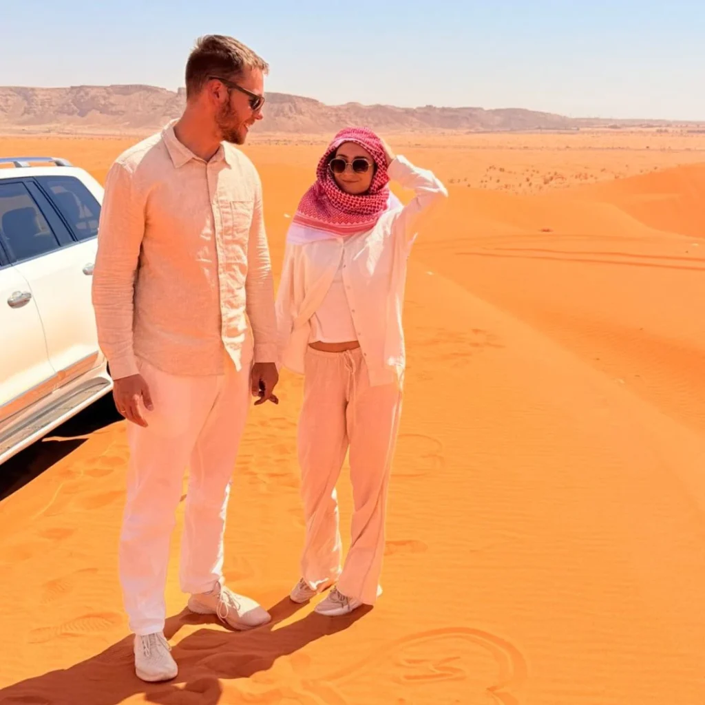 Photographer capturing golden sunset dunes during Desert Safari Photography Tips in Riyadh.