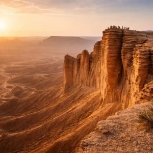 Exploring Edge of the World Riyadh Tour with breathtaking cliff views and vast desert landscape at sunset.