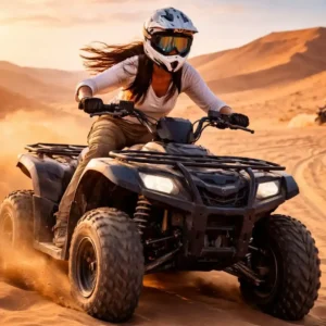 Woman enjoying Your First Quad Biking Riyadh Adventure riding an ATV across golden desert dunes at sunset.
