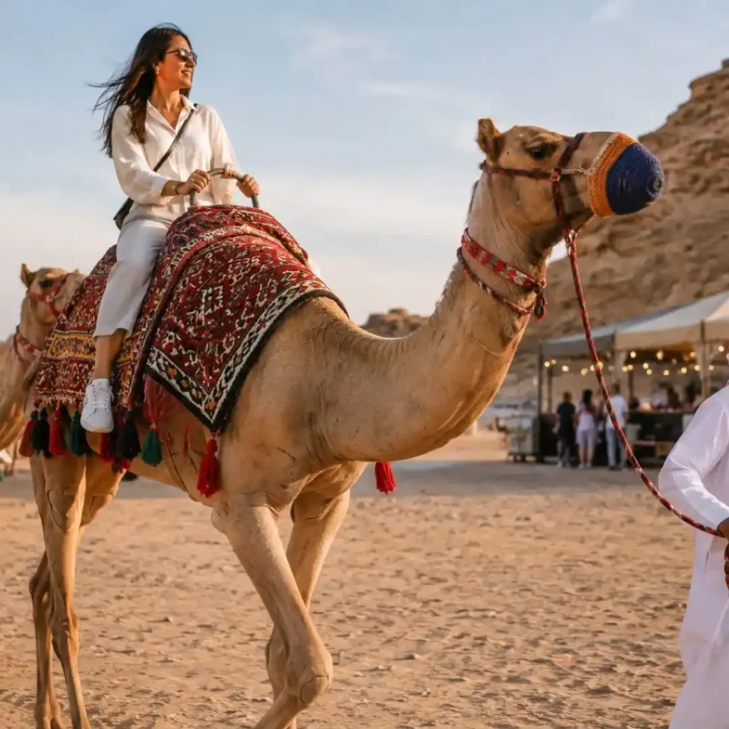 "How to Plan Your Perfect Camel Ride Riyadh – tourists enjoying camels across golden desert dunes with sunset light"
