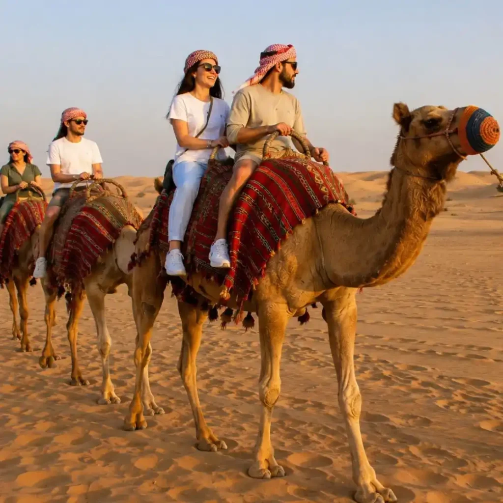 "How safe is an evening desert safari – tourists enjoying a camel ride across golden sand dunes at sunset with guides ensuring safety"